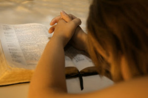 girl praying over Bible