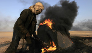 A man works at a makeshift oil refinery site in al-Mansoura village in Raqqa